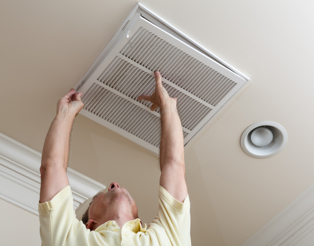 man inspecting a vent